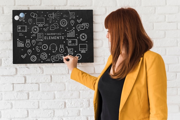 Professionele vrouw die op bord schrijft