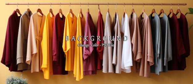 rack with different stylish clothes hanging on yellow wall closeup