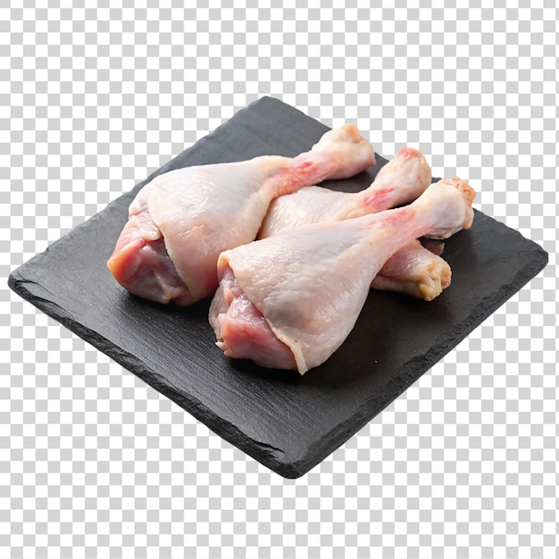 Raw chicken legs on black slate plate isolated on transparent background