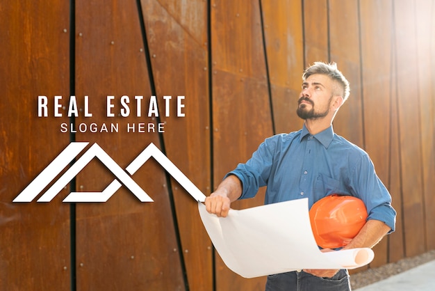 PSD real estate agent looking up and holding plans