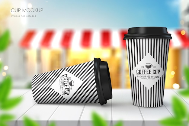 Realistic paper coffee cup mockup of two cups on wooden tabletop with sky and cafe in background