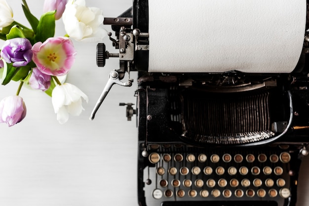 Retro schrijfmachine Machine met papier door bloemen in vaas