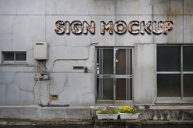 PSD rusty effect business sign mock-up on warehouse facade