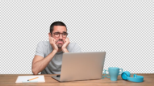 PSD sad young man sitting at his desk