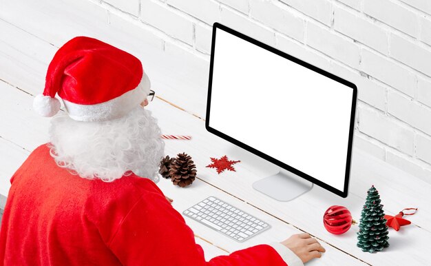 PSD santa claus work on computer concept. isolated display for mockup. christmas decorations on desk. isometric view