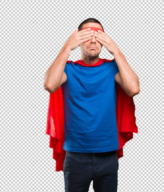 Scared superhero covering his eyes