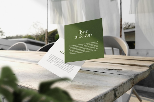 Schone minimale vierkante flyer-mockup drijvend op de bovenste tafel met plant PSD-bestand