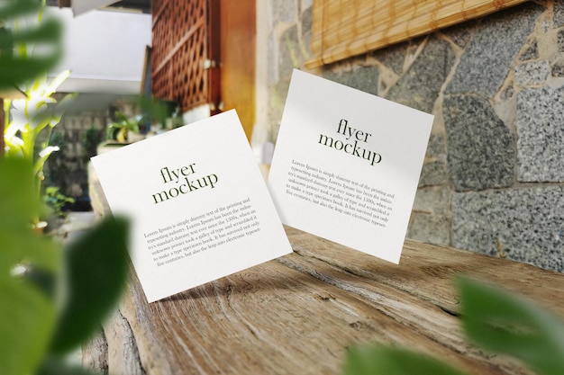 Schone minimale vierkante flyer mockup drijvend op houten bankje met bladeren. PSD-bestand.