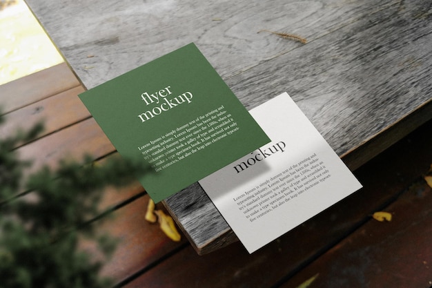Schone minimale vierkante flyer-mockup op houten top met plant PSD-bestand