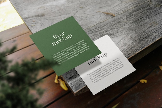 Schone minimale vierkante flyer-mockup op houten top met plant psd-bestand