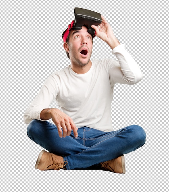 seated young man using a virtual reality glasses