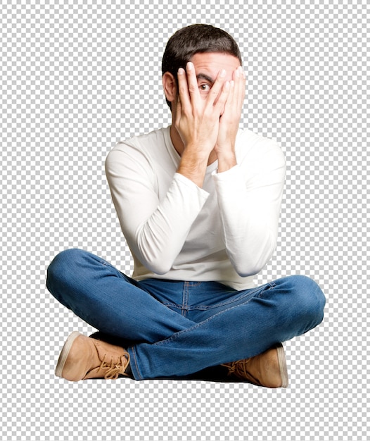 Seated young man with a fear gesture