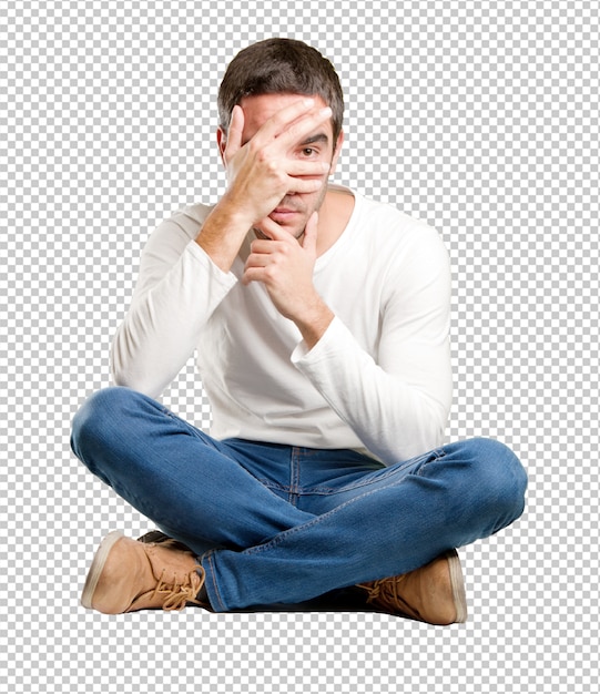 Seated young man with a fear gesture