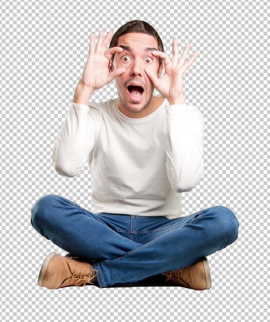 Seated young man with an observe gesture