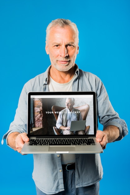 PSD uomo anziano che presenta il modello di laptop