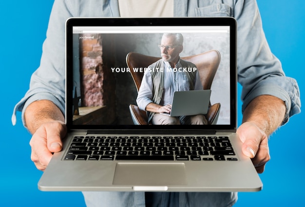 Senior man presenting laptop mockup