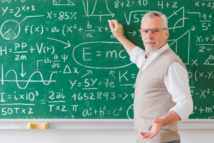 PSD senior teacher with glasses writing on board