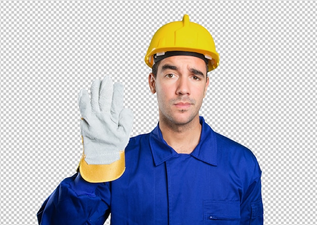 Serious worker with stop gesture on white background