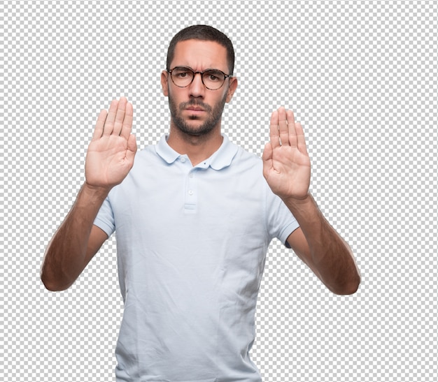 Serious young man doing a stop gesture