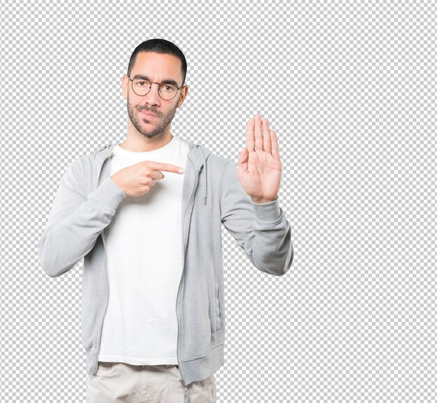 Serious young man making a gesture of stop with his palm