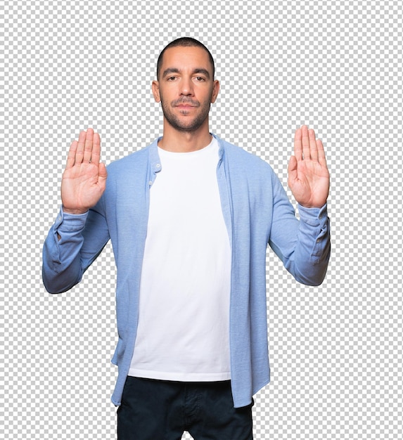 Serious young man making a gesture of stop with his palm