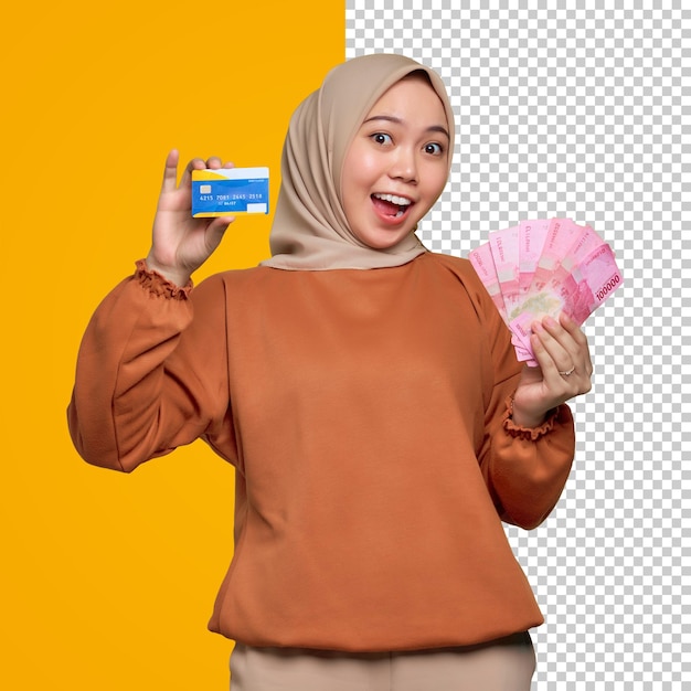 Shocked young Asian woman in orange shirt holding money banknotes and showing credit card