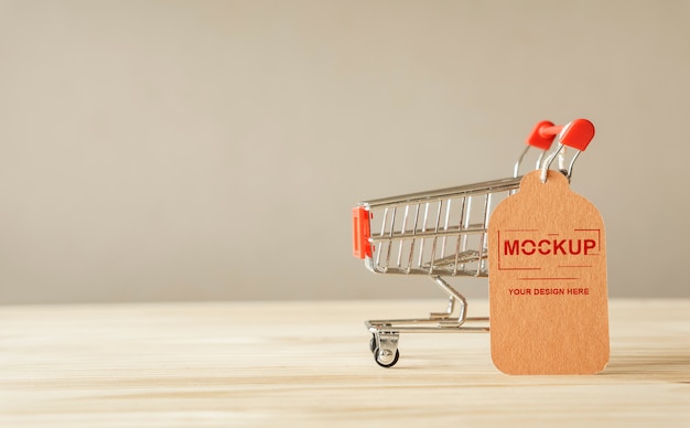 PSD shopping cart with brown price tag on wooden table mockup