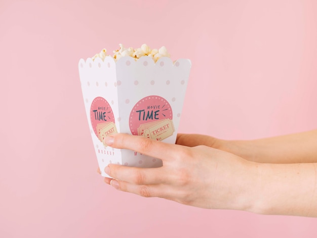 side view of hands holding popcorn cup