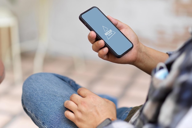 Side view of male hand holding smartphone mockup