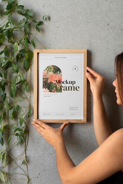 side view woman hanging a picture