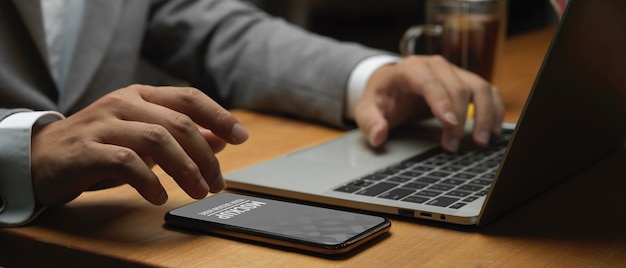 Sidevisning af forretningsmands hånd, der arbejder med smartphone-mockup