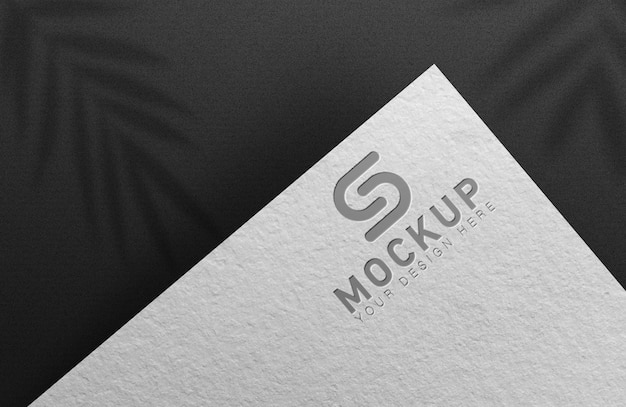 Silver logo mockup embossed on white paper a black background