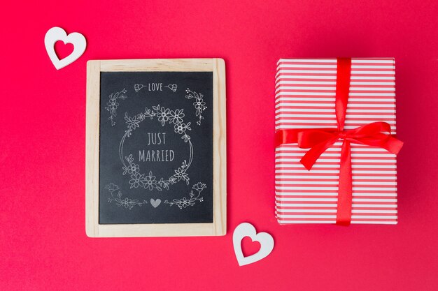 Slate mockup accanto alla confezione regalo per san valentino