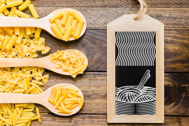 Slate mockup with pasta concept on wooden spoons