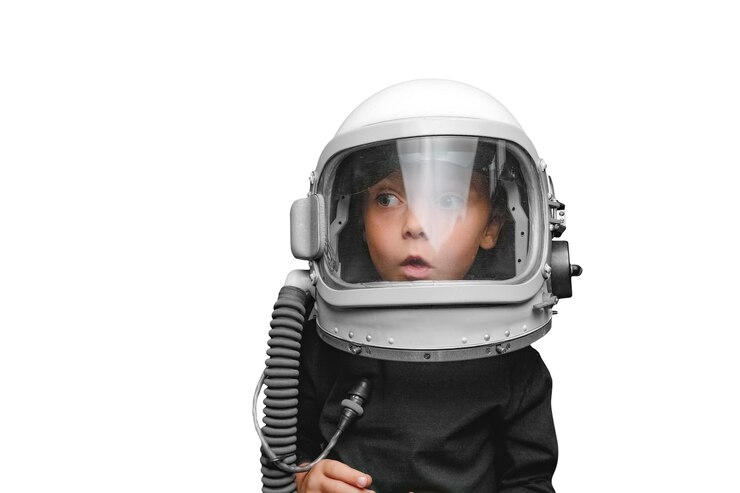 PSD small child imagines himself to be an astronaut in an astronauts helmet