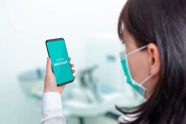 PSD smart phone mockup in hospital laboratory concept. woman with mask holding phone