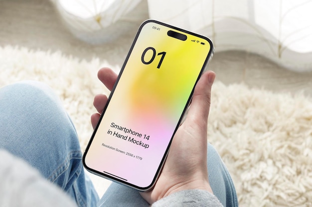 PSD smartphone 14 in mano mockup seduto con uno sfondo di tappeto moderno