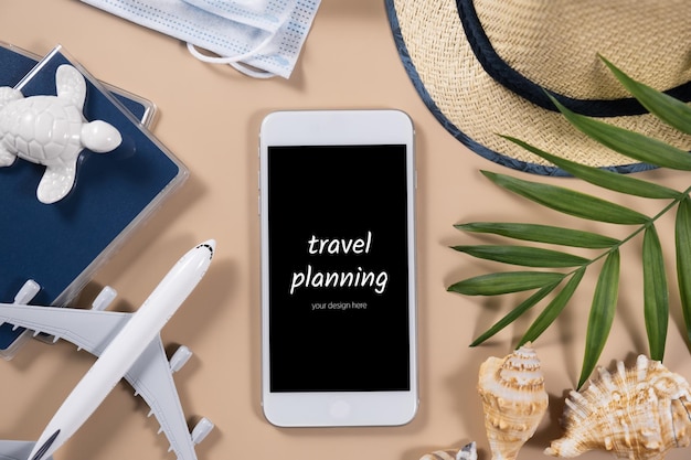 スマートフォン飛行機麦わら帽子とパスポート旅行計画のコンセプトフラットレイ旅行アイテム