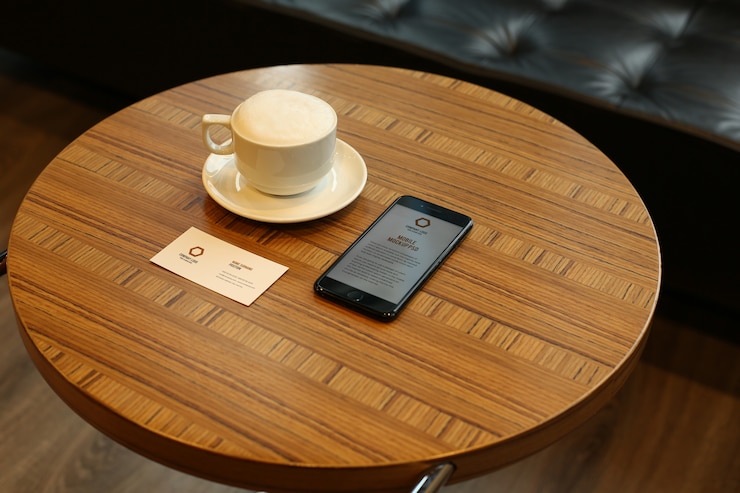 PSD カフェで丸いテーブルにスマートフォンと名刺のモックアップpsd