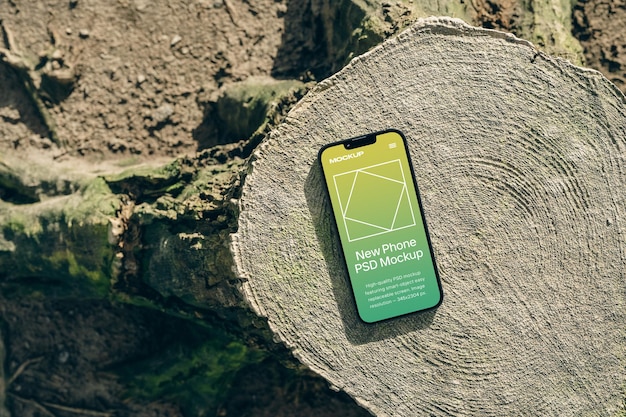 PSD smartphone liggend op een boomstronk realistische branding telefoon schermontwerp mockup