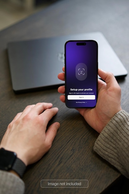 Smartphone Mockup in a mans hand on a wooden office desk
