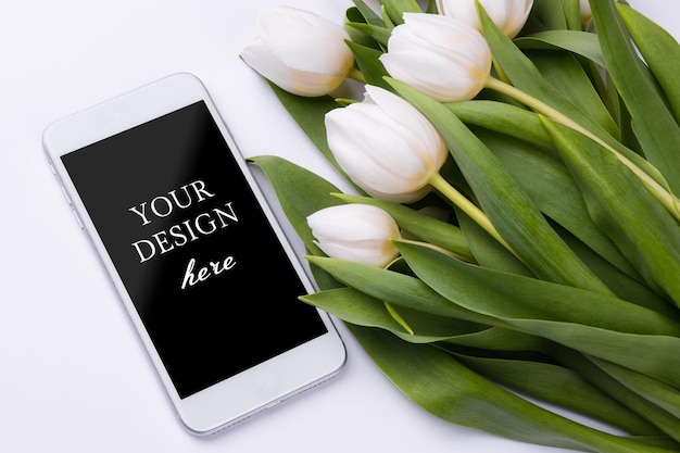 Smartphone mockup with a bouquet of white tulips Device screen mock up for presentation or appl design