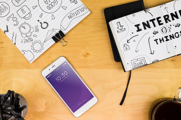 Smartphone mockup with office materials on table