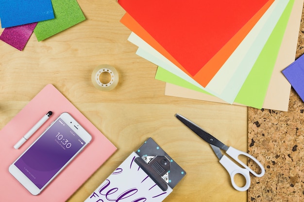 PSD smartphone mockup with office materials on table