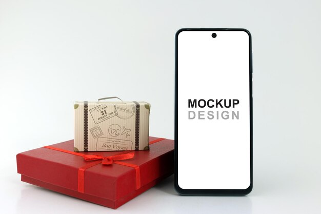 PSD smartphone mockup con confezione regalo rossa e valigia da viaggio