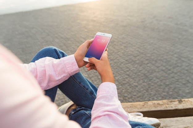 PSD smartphone mockup with woman at the beach