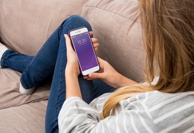 PSD smartphone mockup with woman chilling on couch