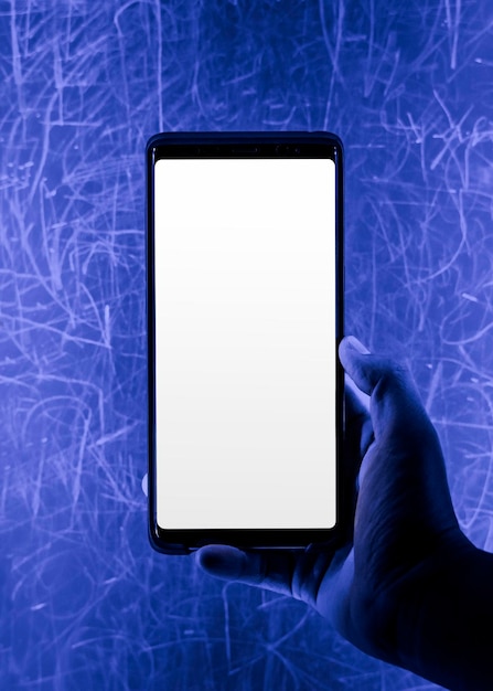 Smartphone screen mockup by a blue grunge wall psd