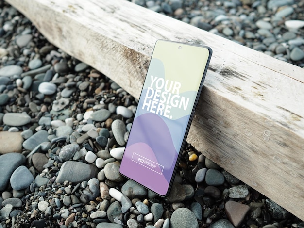 PSD smartphone template mockup on the rocks on the beach
