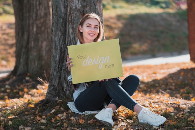 PSD smiley blonde girl holding a banner mock-up